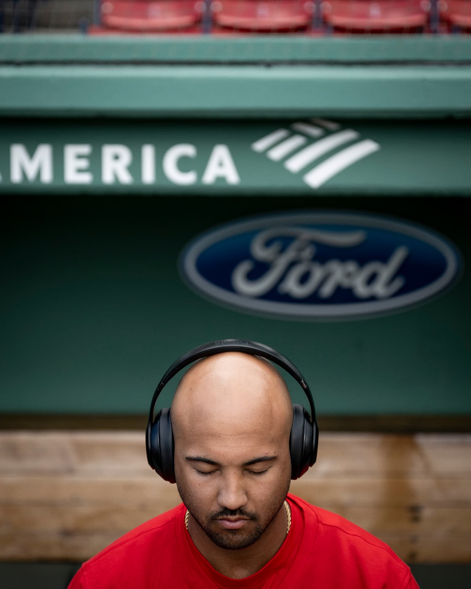 Jamie in the Fenway dugout with headphones on, eyes closed